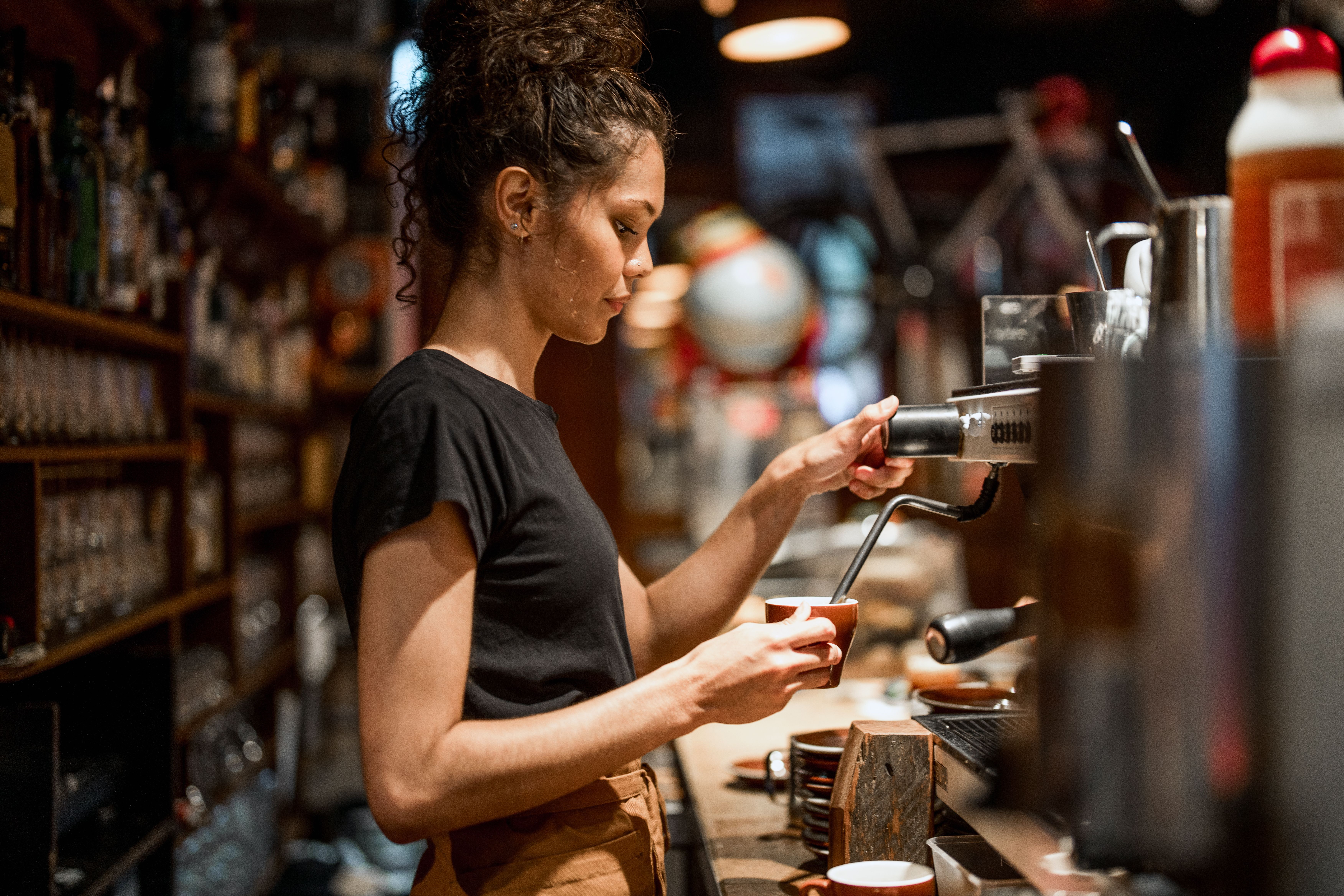 Cafe owner making coffee at the espresso machine